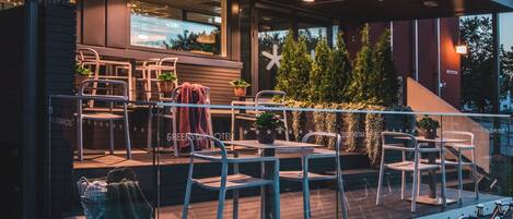 El exterior del Hotel Greenstar con mesas al aire libre y bicicletas.