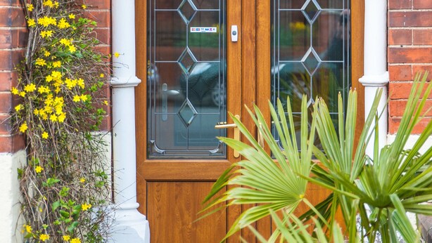 A wooden double door with glass panels and a white archway above it. - Arlana Guest House (Cleethorpes)