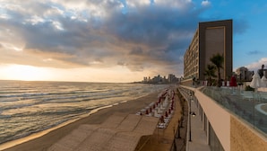 Ein Hotel am Strand mit langer Promenade, Meerblick und moderner Architektur.