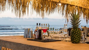 Eine Bar mit Holztresen, Flaschen, Gläsern und einer Ananas.