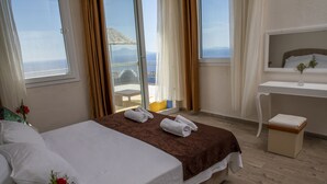 A hotel room with a bed, a desk, a chair, and a view of the sea. - Goknar Knidos Nature Hotel and Farm (Datça)