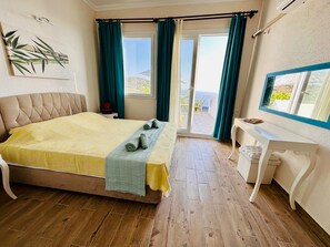 A bedroom with a bed, a desk, and a view of the sea. - Goknar Knidos Nature Hotel and Farm (Datça)