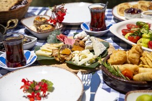 A table set with various dishes including cheese, vegetables, and bread, suggesting a meal setting. - Goknar Knidos Nature Hotel and Farm (Datça)