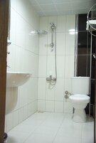 Habitación estándar doble | Baño | Ducha, secador de pelo y toallas