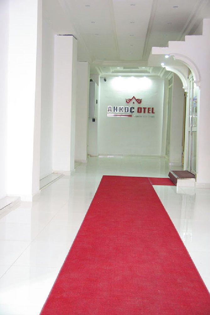 A hotel entrance with a red carpet leading to a reception area.