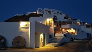 Un bâtiment blanc avec un escalier en pierre menant à un restaurant.