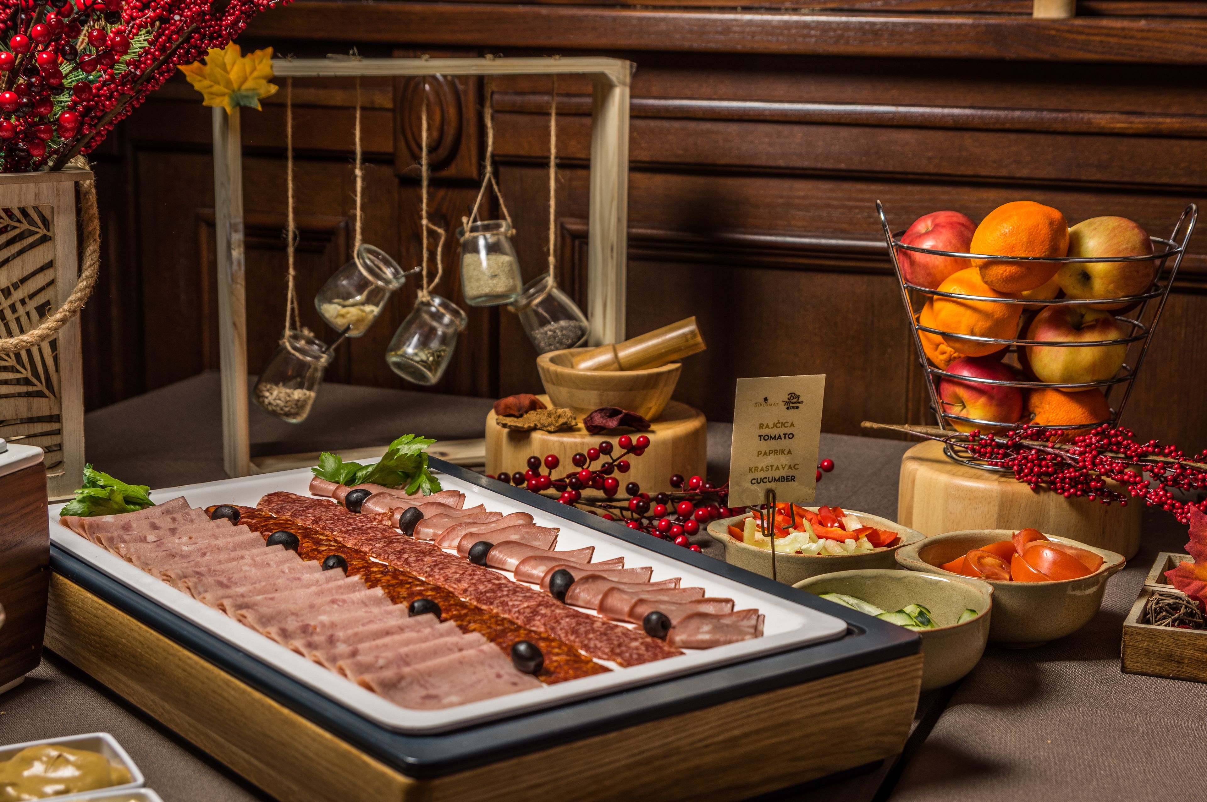 A buffet with various meats, fruits, and vegetables.