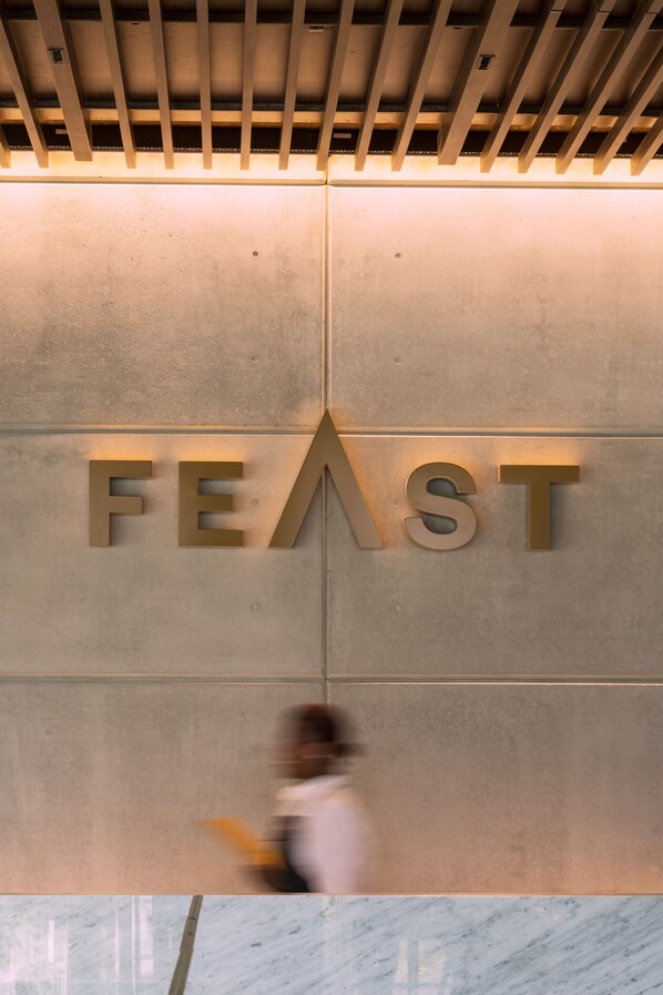 Una señal con la palabra 'FEAST' en una pared.