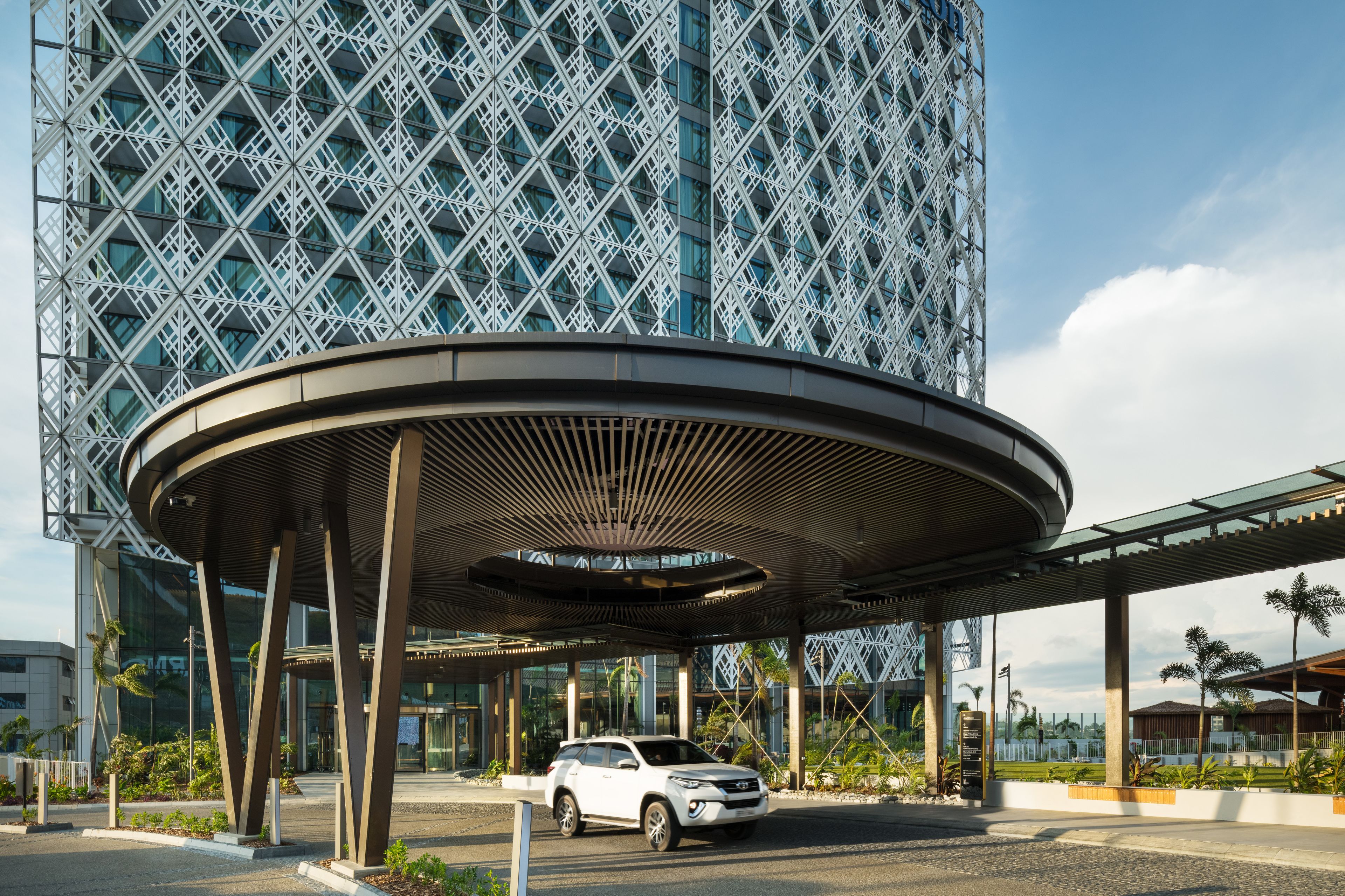 A modern building with a distinctive geometric facade and a covered entrance area.