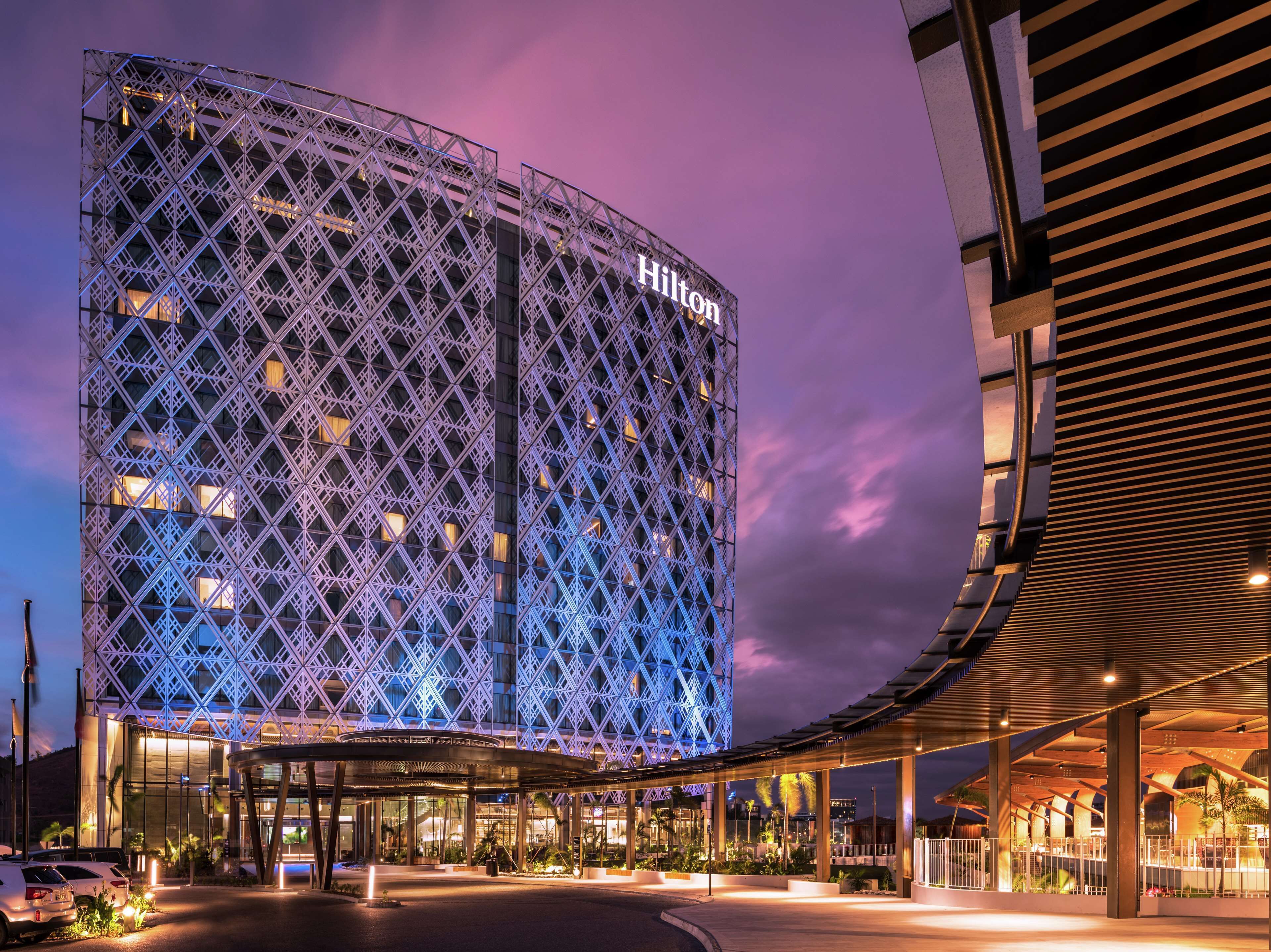 A modern hotel with a distinctive geometric facade and a prominent Hilton sign.