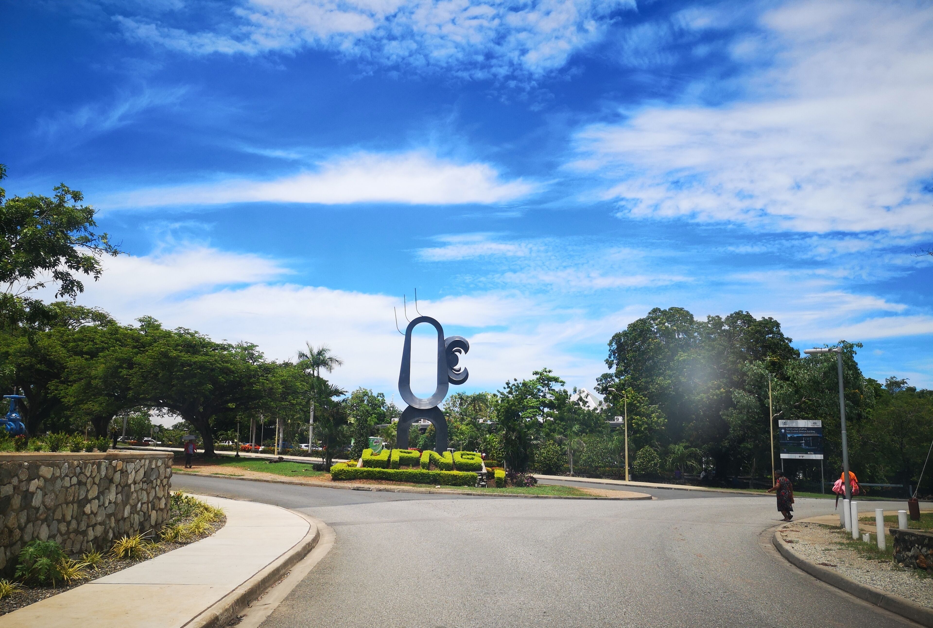 A road intersection with a large, modern sculpture in the center.