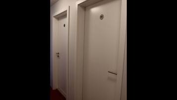A hallway with two white doors, one marked with a "WC" sign.