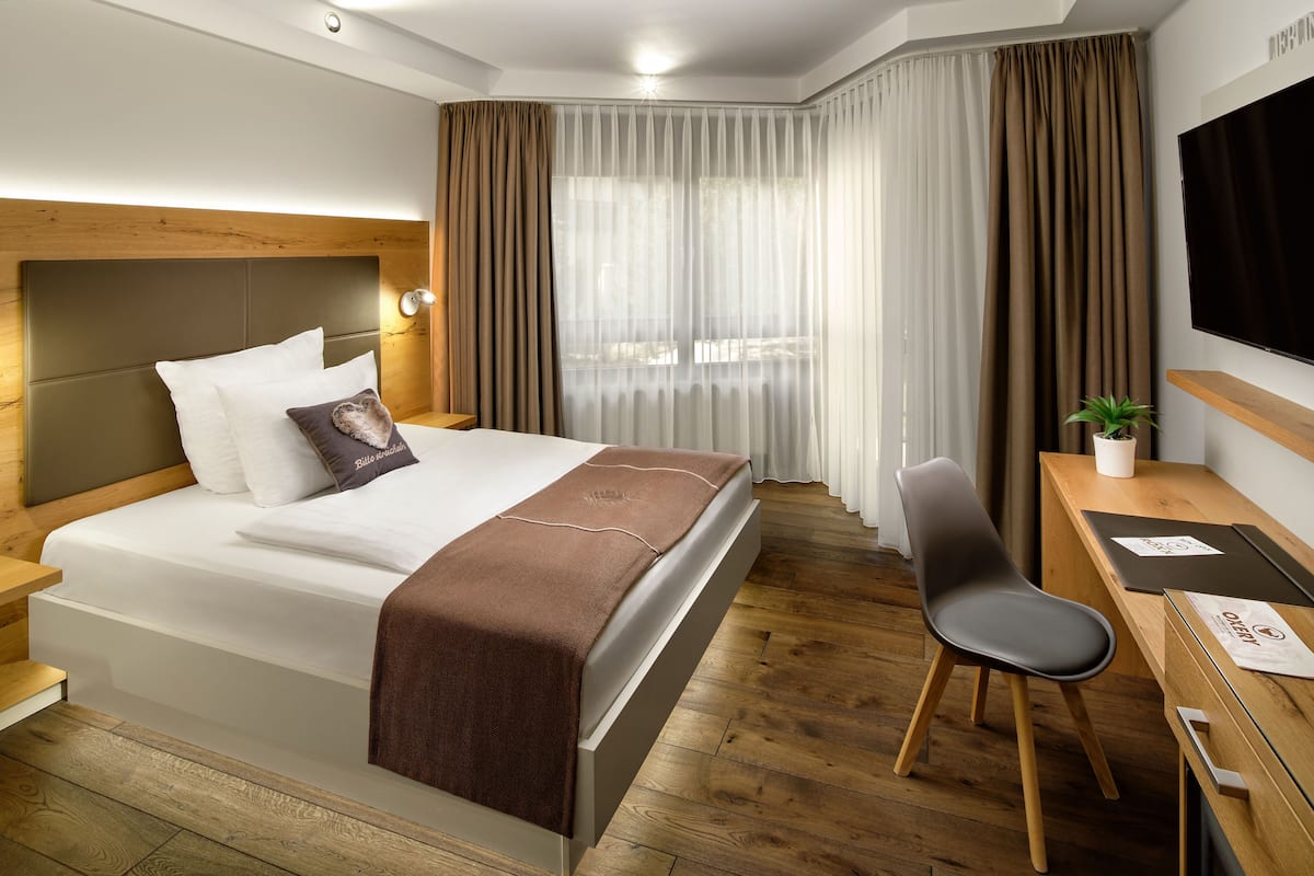 Une chambre d’hôtel moderne, dotée d’un grand lit, d’un bureau et d’une chaise.