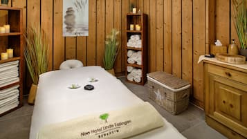 Relax in a serene spa room with a comfortable bed, bathtub, and soothing artwork.