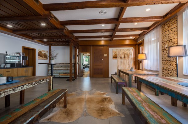 Un interior espacioso con vigas de madera, un banco central y una alfombra de piel.