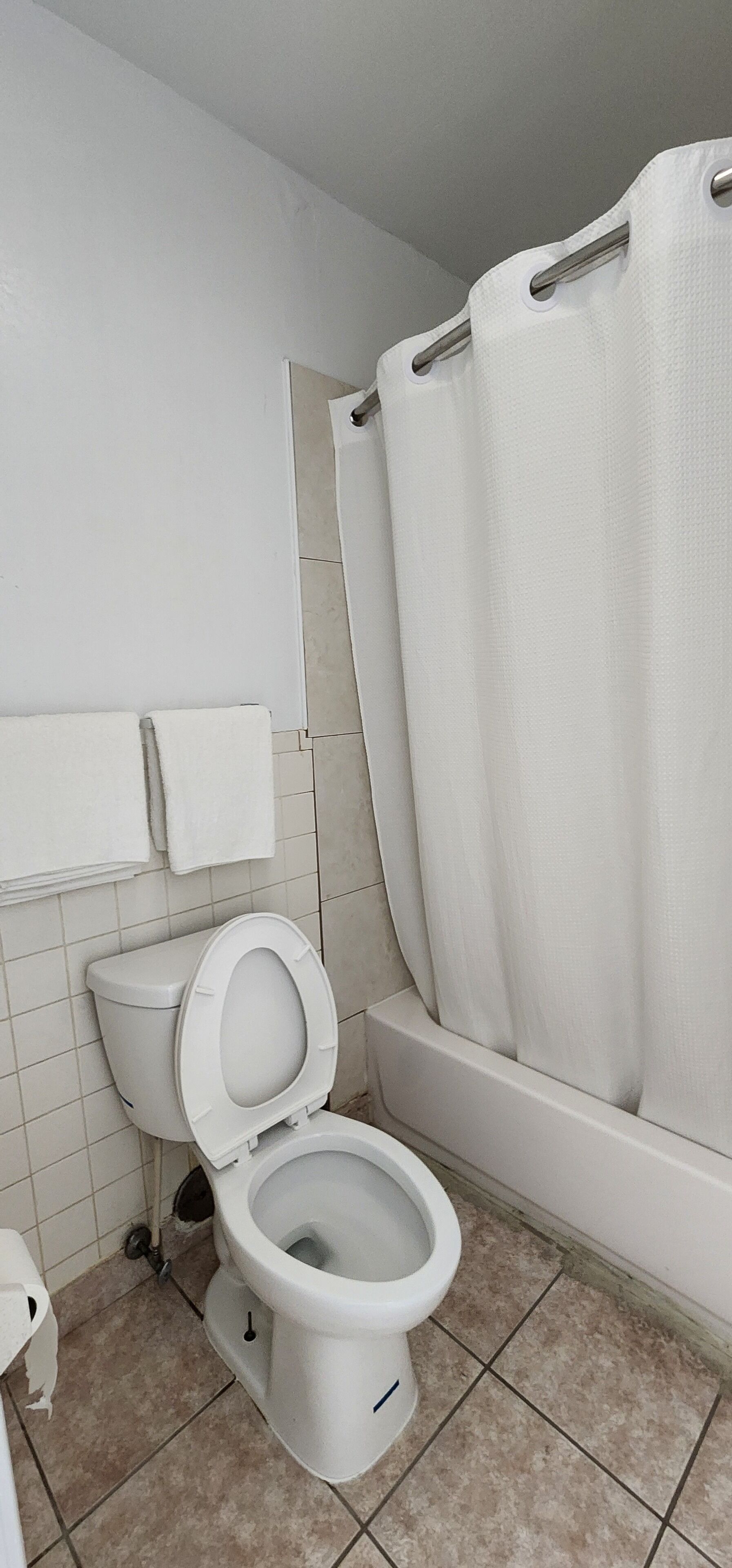 Un baño con inodoro, bañera y cortina de ducha.