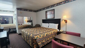 A hotel room with two beds, a desk, a chair, a table, a lamp, and a mirror. - Turnpike Motel Richmond VA by Hotel O US 60 (Richmond)