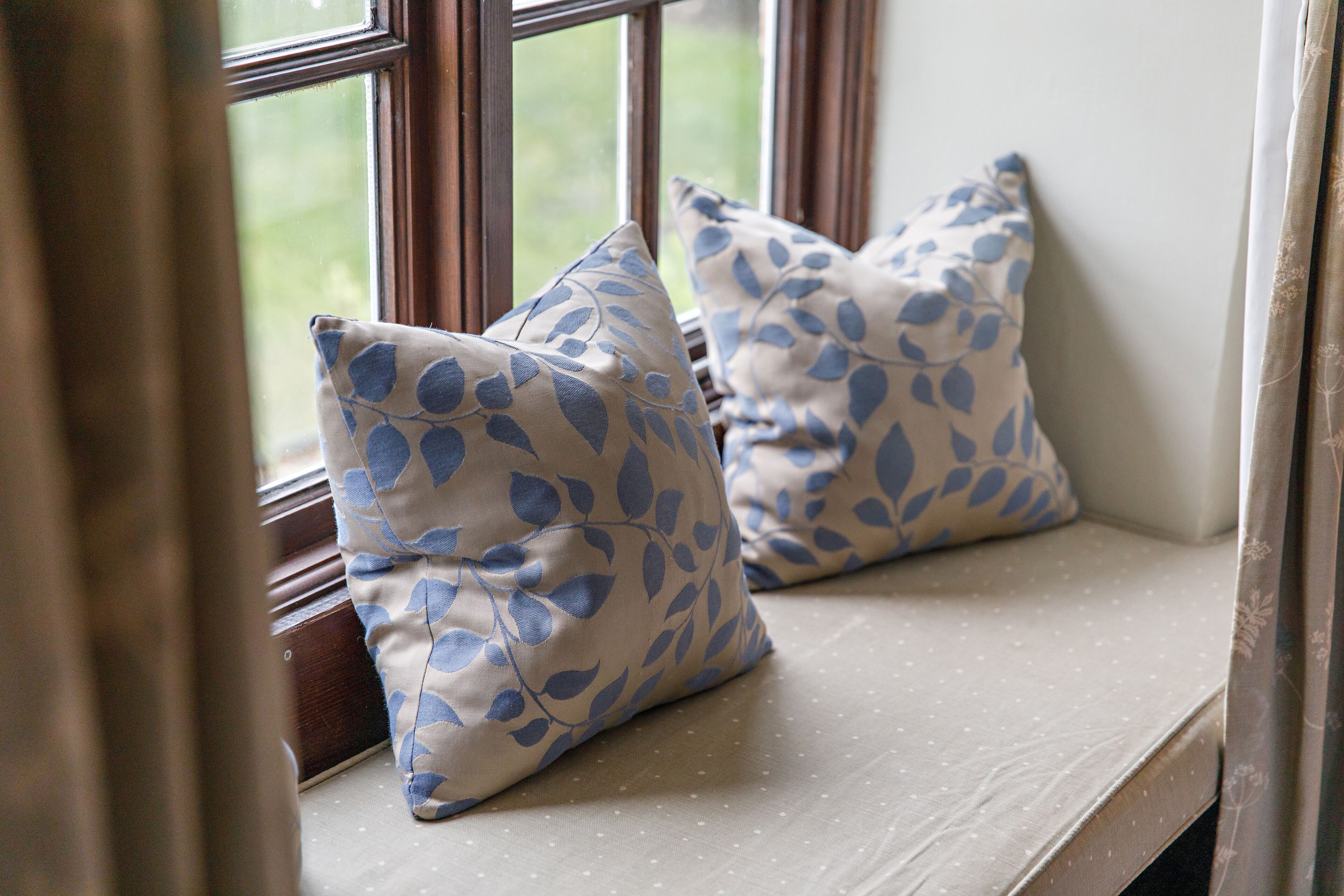 A window seat with two cushions.