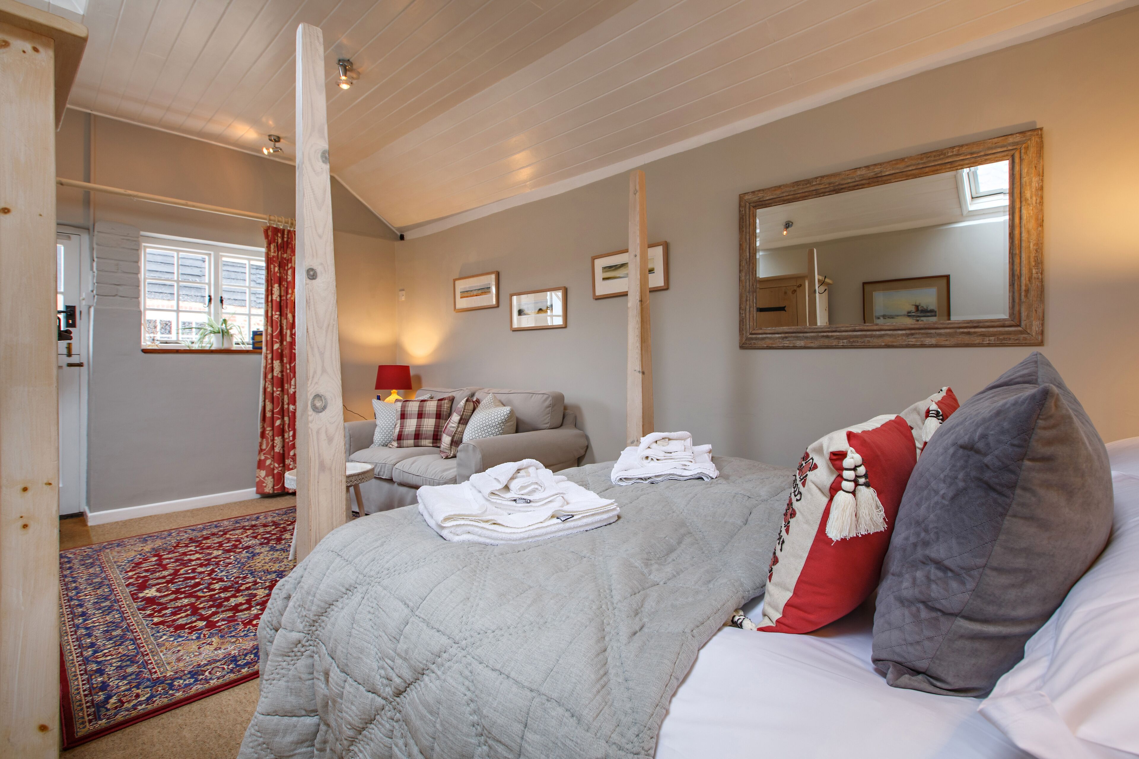 Une chambre à coucher avec un lit, un grand miroir et une vue sur l’extérieur.
