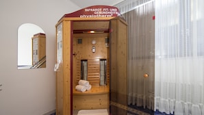 A wooden physiotherapy room with a bench, towels, and a clock. - Kurhotel Unter den Linden (Bad Fuessing)