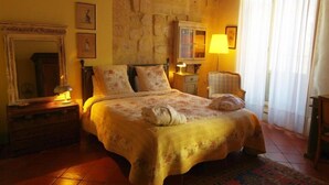 Ein gemütliches Schlafzimmer mit Bett, Schminktisch, Spiegel und Lampe.