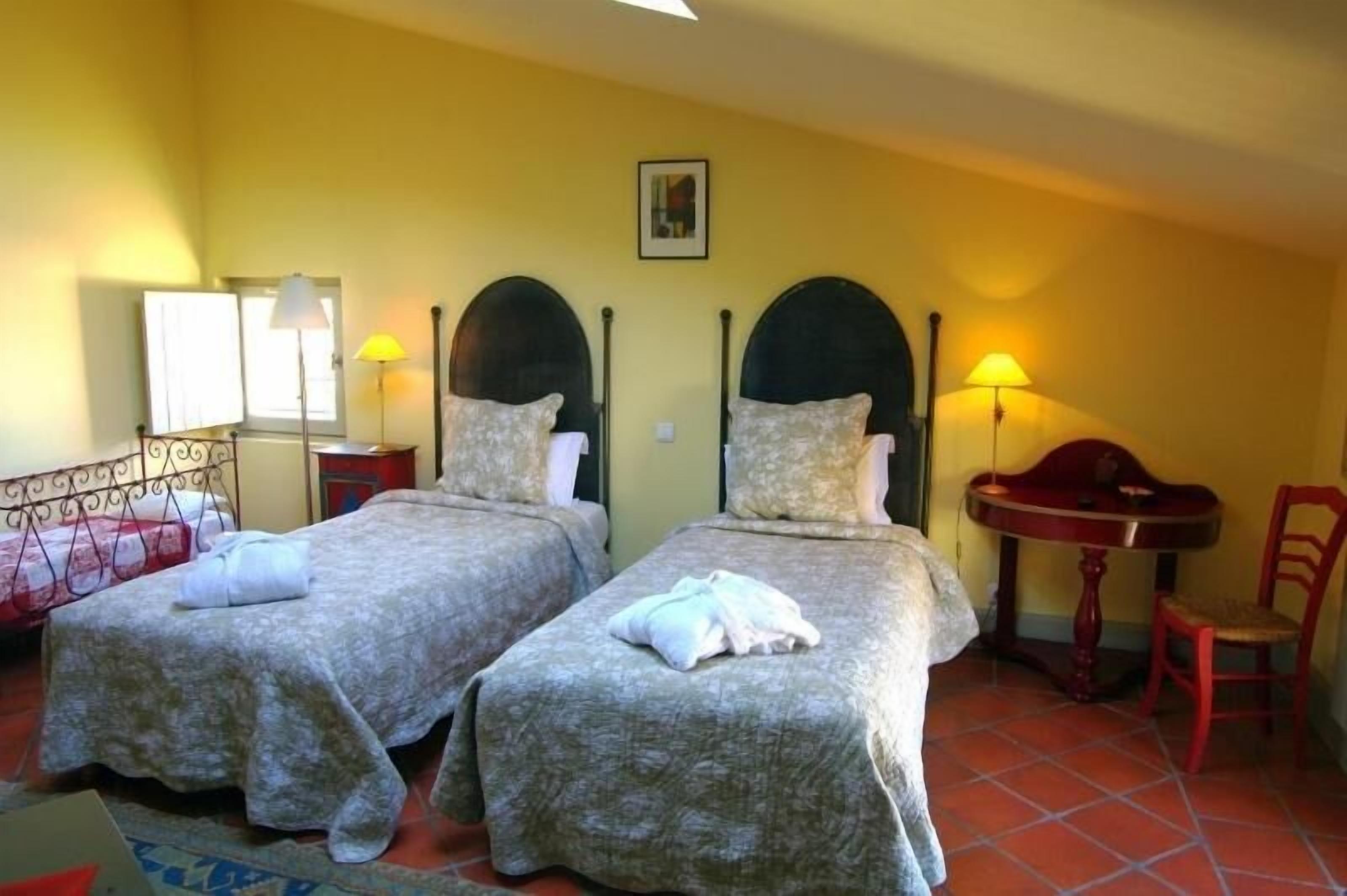Una habitación con dos camas, una mesa y una silla.