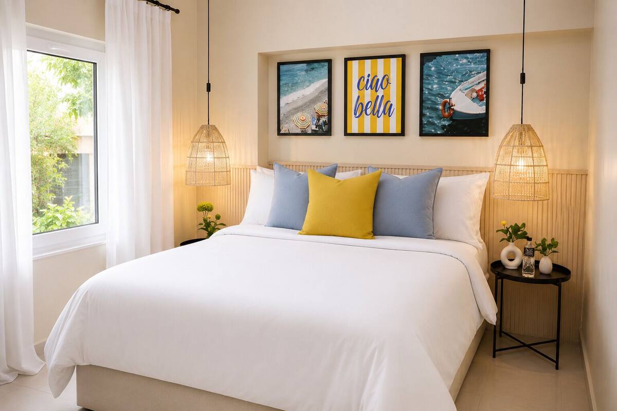 A neatly arranged bedroom with a large bed, two bedside tables, and three framed artworks on the wall.