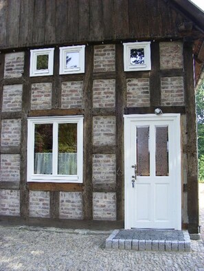 A traditional half-timbered building with a white door and windows.