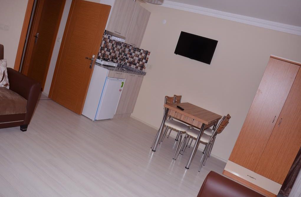 A compact living space with a kitchenette, a dining area, and a wardrobe.