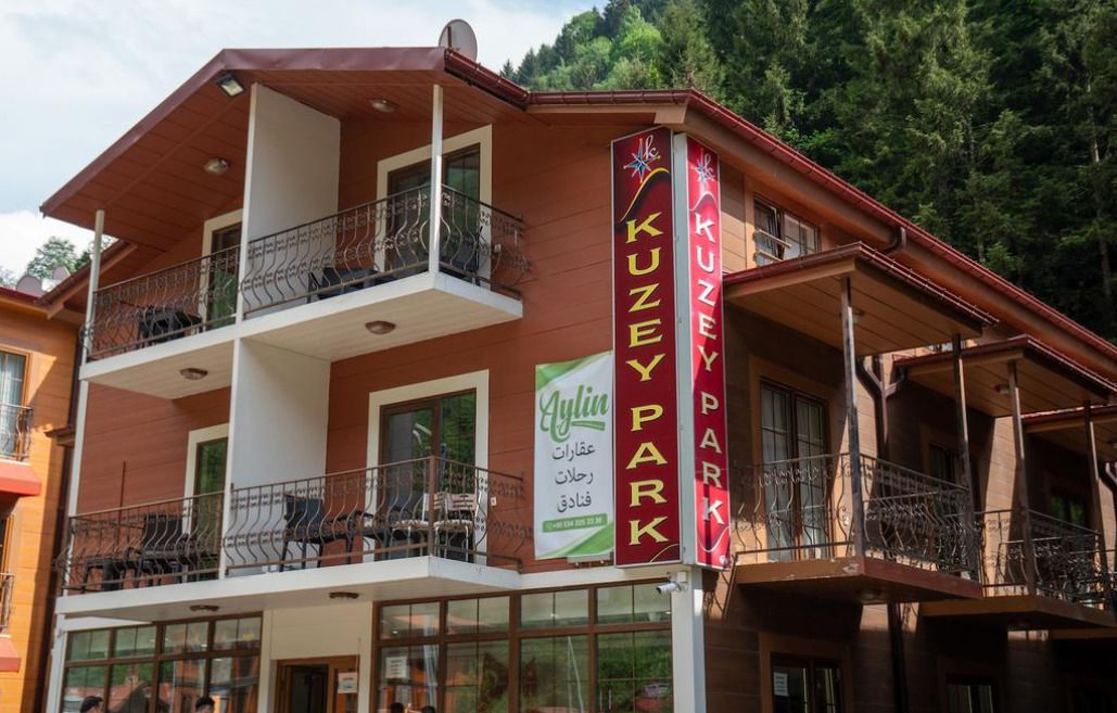 Un edificio de dos plantas con balcones y un letrero que dice "KUZEY PARK".
