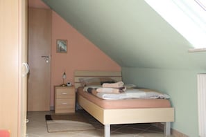 Una camera da letto con un letto, un comodino e una porta.