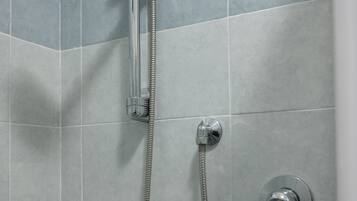 A shower with a handheld showerhead and a wall-mounted faucet.