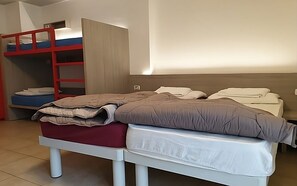 A bedroom with a bunk bed, a single bed, and a wardrobe.