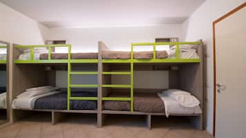 A room with bunk beds, a door, and a tiled floor.