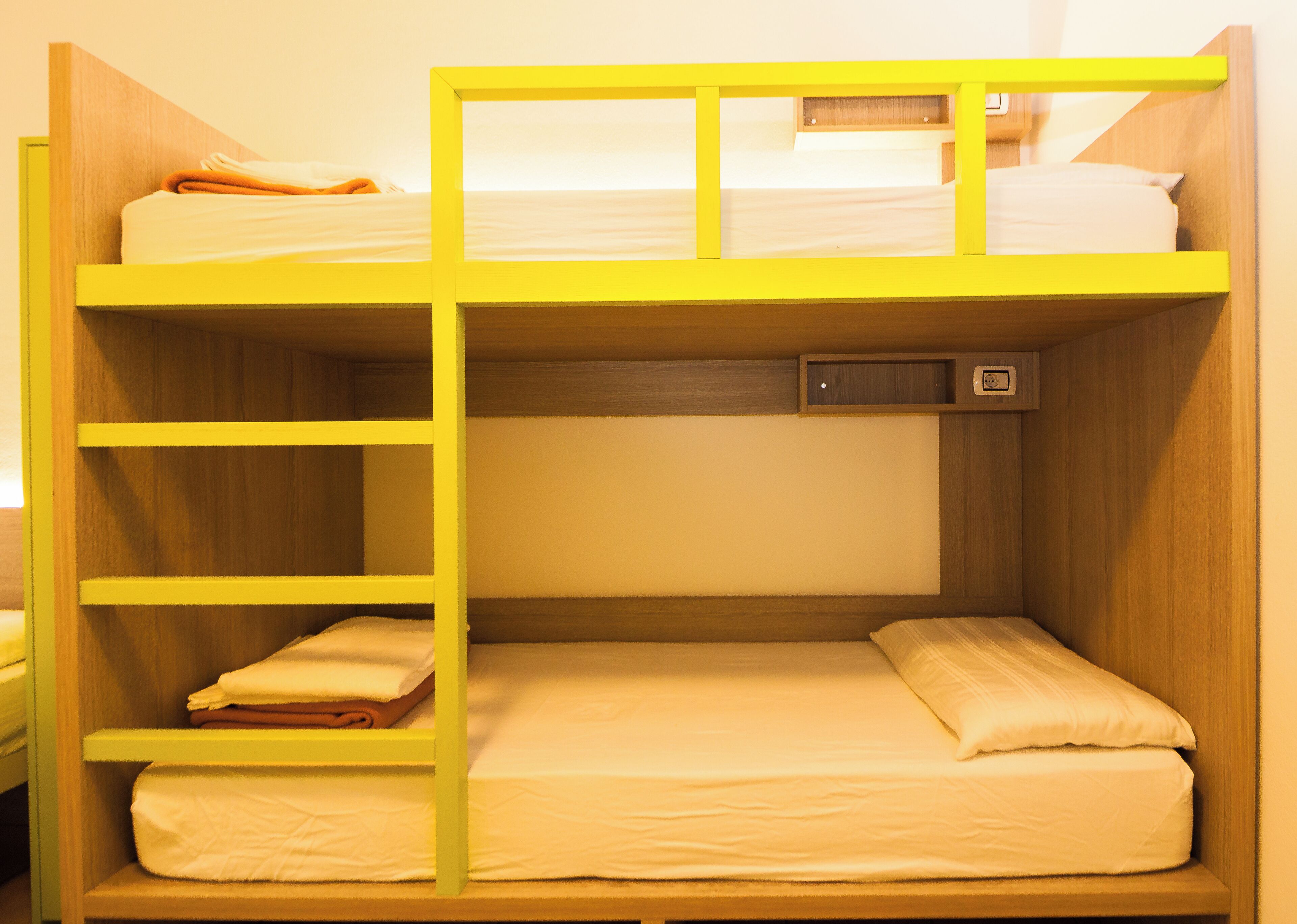 A bunk bed with a wooden frame and a yellow ladder.
