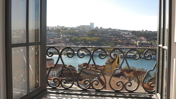 A balcony with a view of a river and cityscape. - Mo House (Porto)