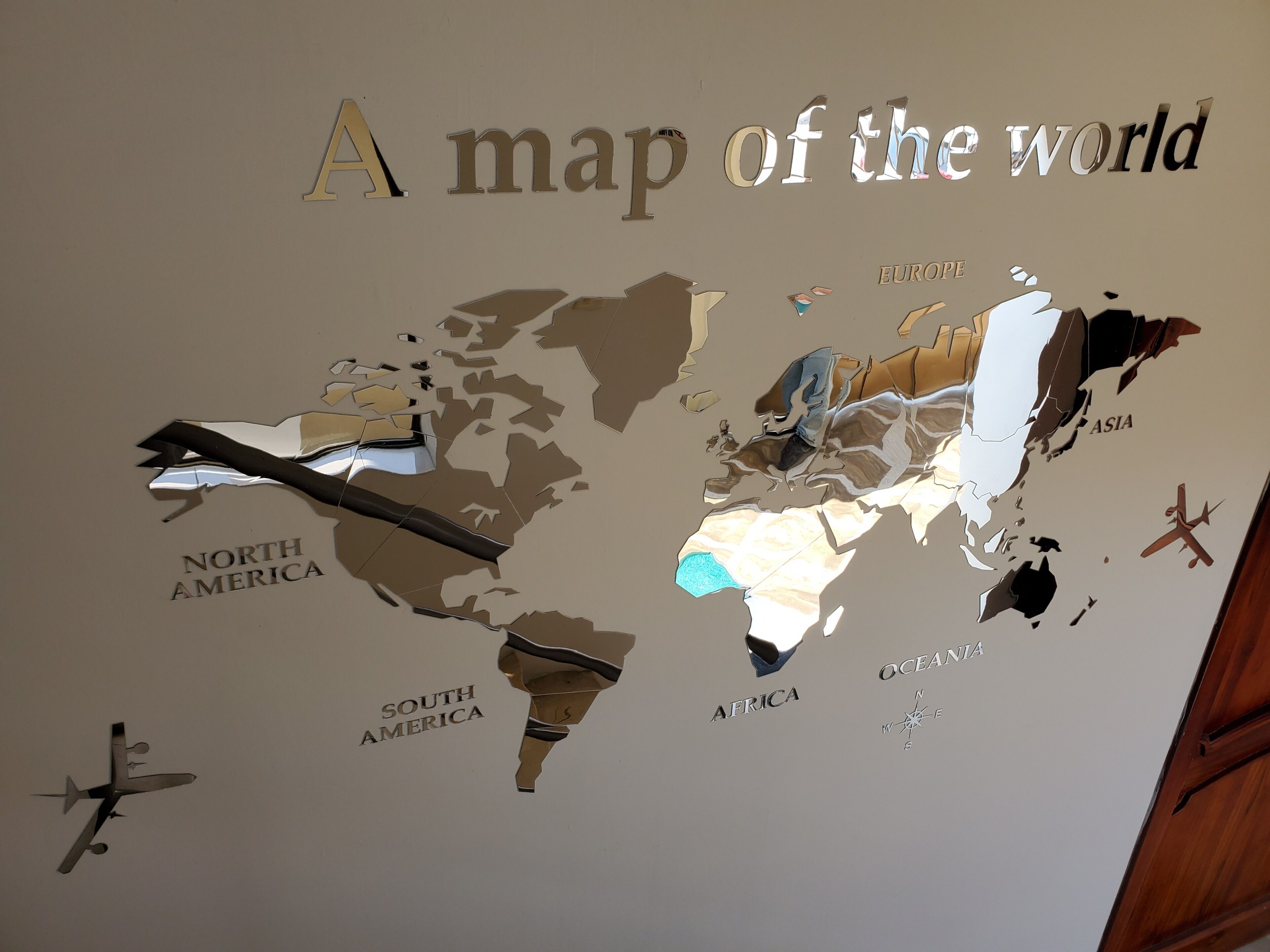 A wall with a world map and airplane silhouettes.