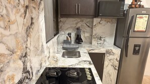 Eine Küche mit Gasherd, Backofen, Mikrowelle und Kühlschrank.