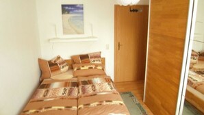 Une chambre à coucher avec un lit, une armoire en bois et un tableau accroché au mur.