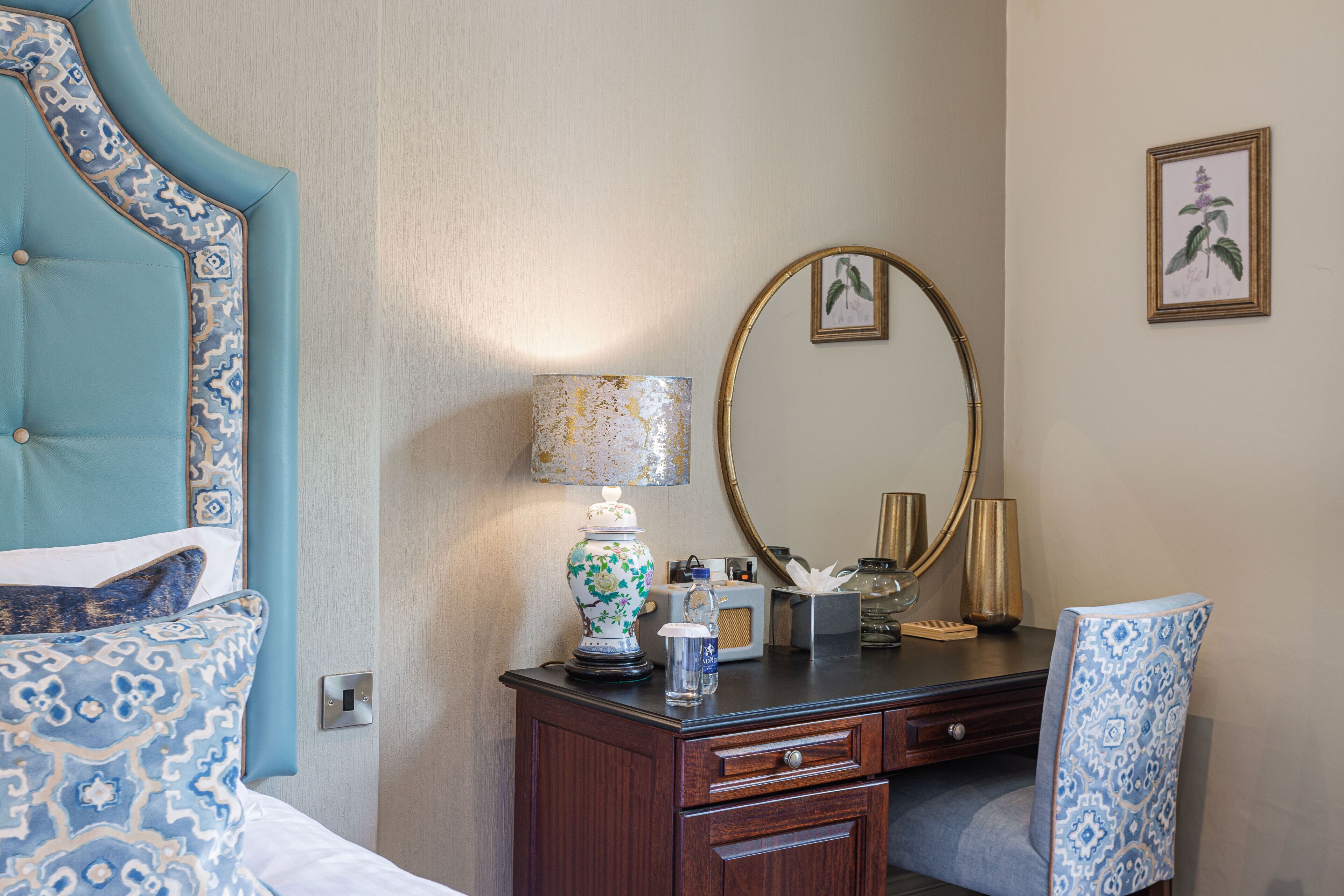 Une chambre d’hôtel avec un lit, une commode, un miroir et une chaise.