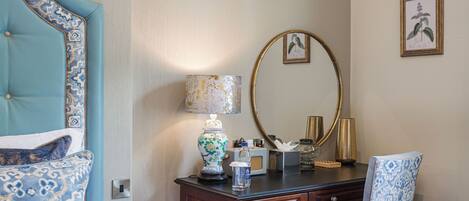 A hotel room with a bed, a dresser, a mirror, and a chair.