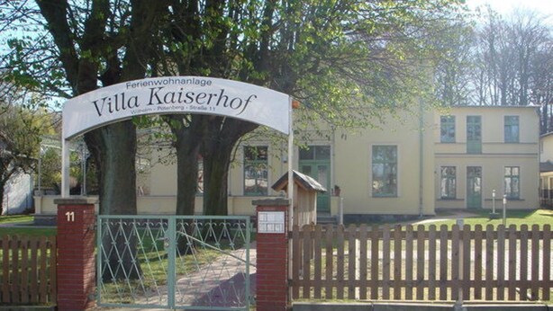 A gated entrance to Villa Kaiserhof, a residential property with a brick gate and a sign above it. - Villa Kaiserhof (Zinnowitz)