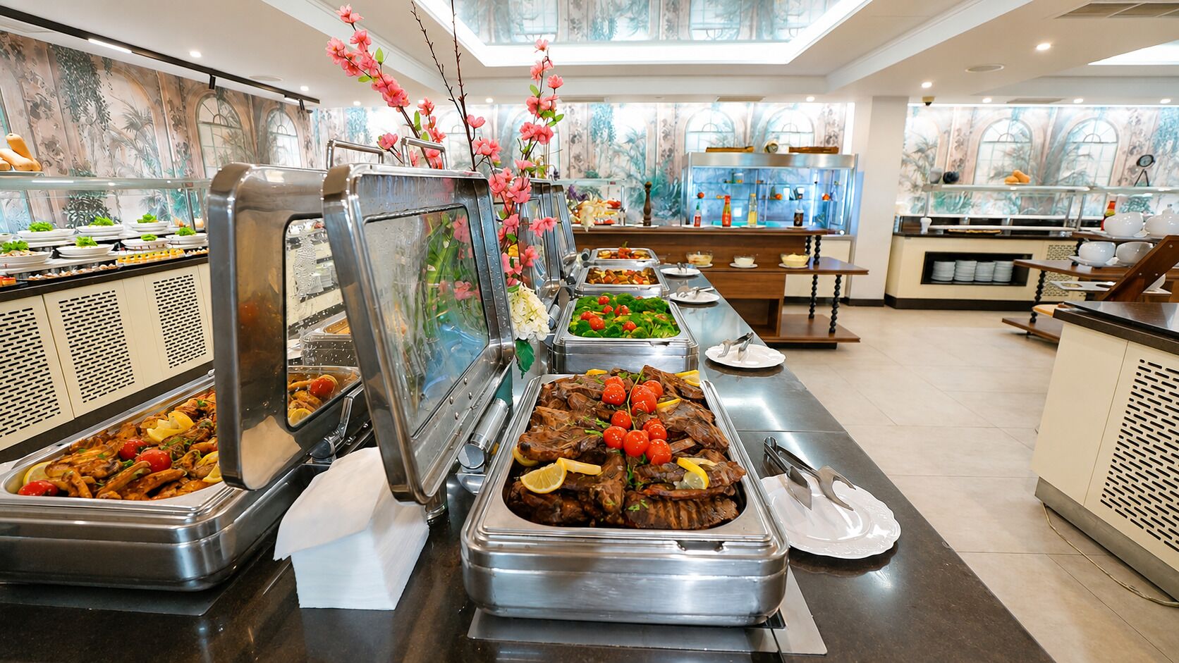 Una mesa de buffet con distintos alimentos y una decoración floral.