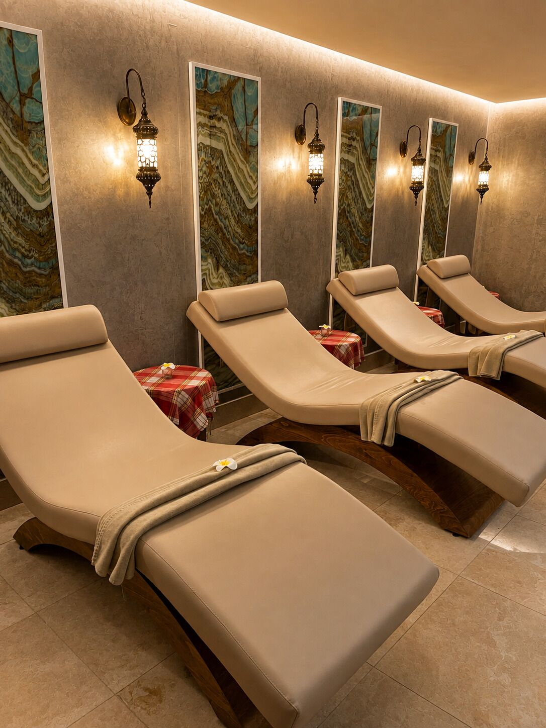 Um espaço de spa com várias poltronas reclináveis, iluminação embutida e um design de parede semelhante a mármore.