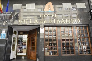 Exterior del Hotel Villa de Ribadeo con una entrada destacada, ventanas amplias y un logotipo sobre la entrada.