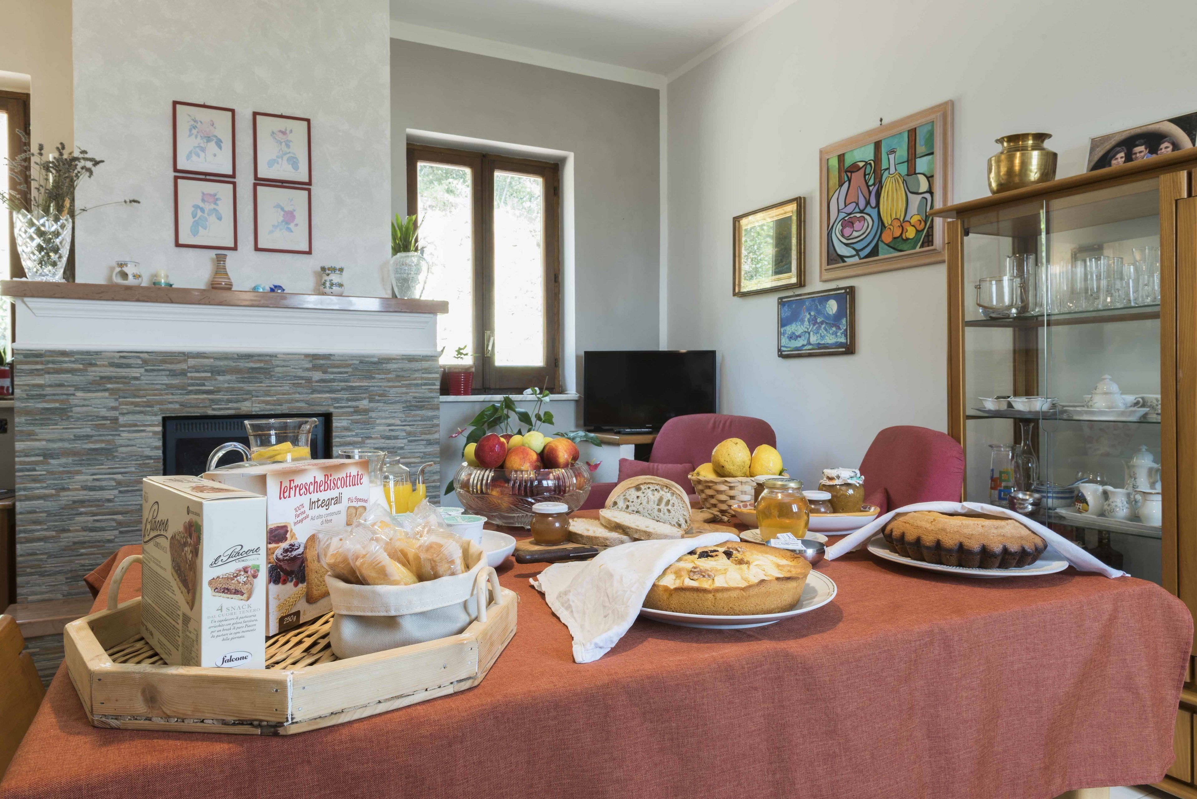 Un coin repas avec une table mise pour le petit-déjeuner, comprenant des viennoiseries, du pain et des fruits.