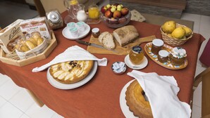 A breakfast table with various food items, including bread, pastries, and a fruit bowl. - Albachiara Casa Di Campagna B&B (Ogliastro Cilento)