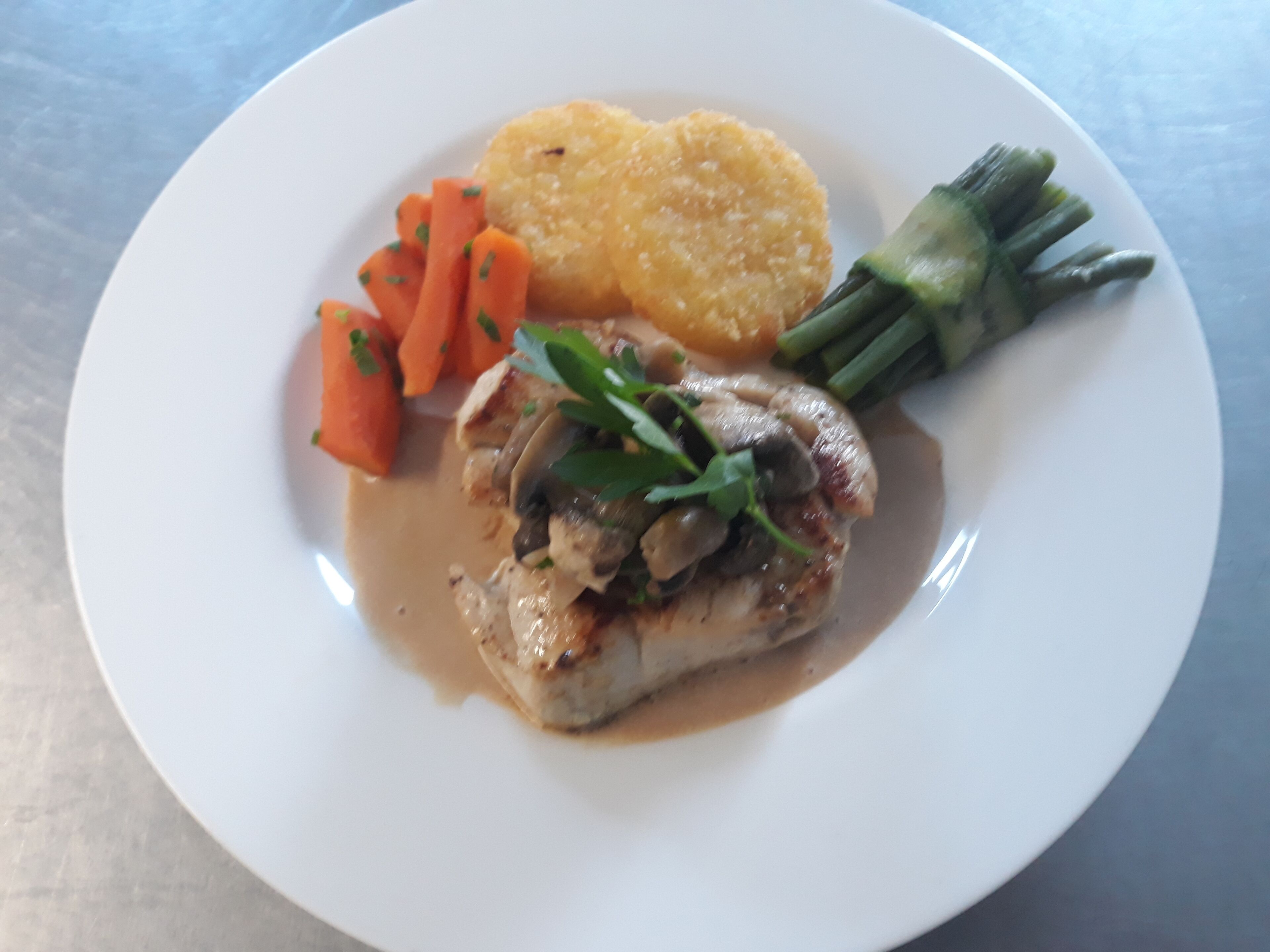 Un piatto con carne, carote, fagiolini e una patata.