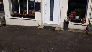 A building with a white facade, a door, and windows with flower boxes. - Hôtel de la Gare (Sainte-Gauburge-Sainte-Colombe)