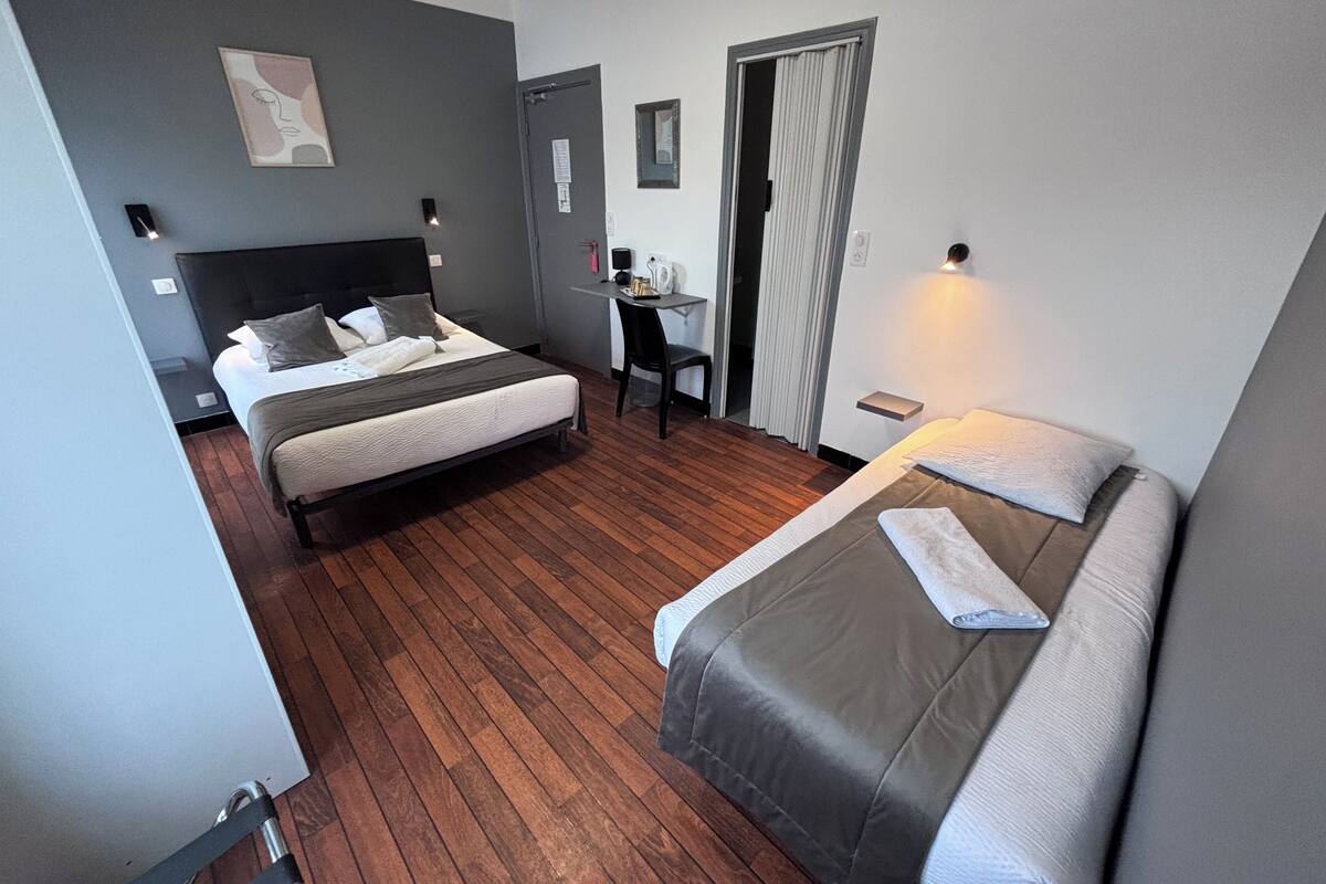 A hotel room with a bed, a desk, and a chair.